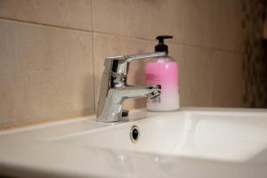 un lavandino in bagno con rubinetto e una bottiglia di sapone di MiraLeón a León