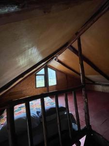 Cette chambre mansardée comprend un lit et deux fenêtres. dans l'établissement Ecolodge las tunas, à Cusco