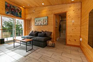 sala de estar con sofá y mesa en 1-bedroom knotty Pine cabin w sauna & jacuzzi en Sooke