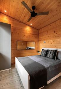 sypialnia z łóżkiem i wentylatorem sufitowym w obiekcie 1-bedroom knotty Pine cabin w sauna & jacuzzi w mieście Sooke