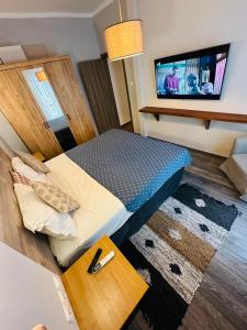 um pequeno quarto com uma cama e uma televisão de ecrã plano em Apartment Dimitris em Atenas