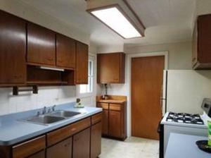 a kitchen with wooden cabinets and a sink and a refrigerator at LH Guest house in Lake in the Hills