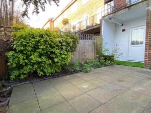 a patio in front of a house with a fence at Redhill Town Centre Garden Flat in Redhill