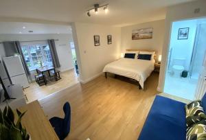 a bedroom with a bed and a living room at Redhill Town Centre Garden Flat in Redhill