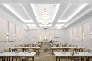 an empty classroom with tables in a room with windows at The Karol Hotel, St. Petersburg Clearwater, a Tribute Portfolio Hotel in Clearwater