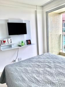 een slaapkamer met een bed en een flatscreen-tv bij Lindo Flat completo em Intermares 404 in Cabedelo