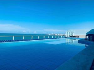 a swimming pool with a view of the ocean at Lindo Flat completo em Intermares 404 in Cabedelo