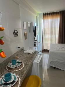 a room with a bed and a counter with cups and plates at Lindo Flat completo em Intermares 404 in Cabedelo