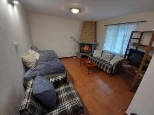 een woonkamer met een bank en een open haard bij SERRADO Da EIRA in Lajes das Flores