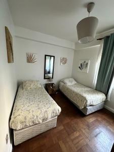 a bedroom with two beds and a mirror at Hostal del Cerro in Santiago