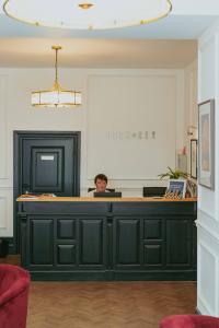 a man sitting at a reception desk in an office at Lock and Key Boutique Hotel - Duke Street in Liverpool