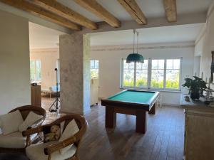 a living room with a pool table and chairs at Vila Bellevue in Jablonec nad Nisou