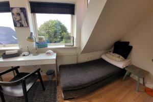 a room with a bed and a desk and a window at Skønt hus - tæt på Givskud Zoo og Legoland in Give