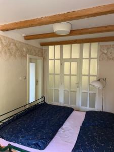 a bedroom with a bed and a lamp and windows at Vila Bellevue in Jablonec nad Nisou