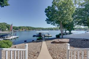 a walkway leading to a lake with a white fence at Private Dock and 4 Decks Lake Ozark Retreat! in Gravois Mills