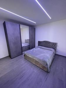 a bedroom with a large bed and a mirror at Appartamento Tortona in Tortona