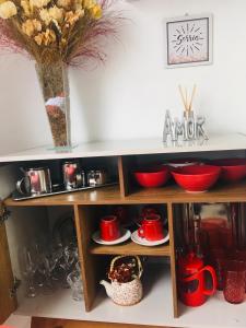 a cupboard with red dishes and a vase at Espaço Zen - Equilíbrio da Alma in Guarujá +16 photos