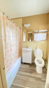 Un baño con inodoro, bañera y lavabo. en Rolphton Motel and Restaurant, en Moor Lake Station