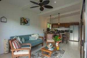 sala de estar con sofá y cocina en Namaitamí Casa Hermosa con AC y piscina a Solo 650 Metros del Parque Nacional Cahuita, en Cahuita