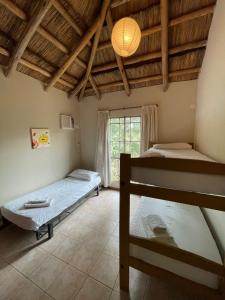 1 dormitorio con 2 camas y ventana en don isidro cabaña alta en La Paz