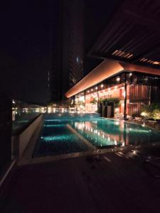 un edificio con piscina por la noche en Budget Homestay by The RUM, en Putrajaya