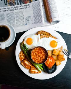 a plate of breakfast food with eggs and beans and a cup of coffee at Lock and Key Boutique Hotel - Duke Street in Liverpool