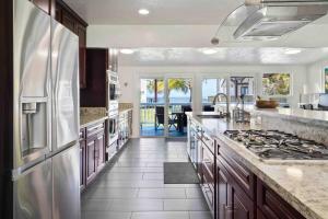 a kitchen with a refrigerator and a stove top oven at ~Naupaka Breeze~Ocean View w/AC- 30 day stays in Laie