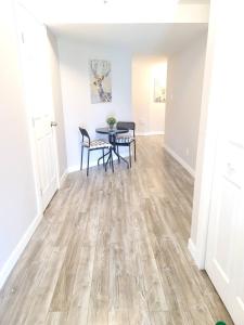 a dining room with a table and chairs on a wooden floor at Cozy Private Suite in Winnipeg