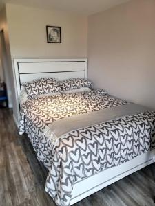 białe łóżko z czarno-białą kołdrą w obiekcie Cozy Private Suite w mieście Winnipeg