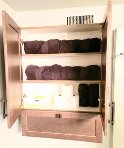 une armoire ouverte avec des serviettes et des articles de toilette dans la chambre dans l'établissement Cozy Private Suite, à Winnipeg