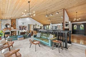 a living room with a green couch and tables at Luxe Lake Home Reflect Recharge and Reconnect in Nine Mile Falls