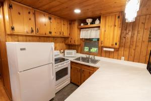 a kitchen with wooden cabinets and a white refrigerator at Athens and Albany's Hillside Haven in Albany +17 photos