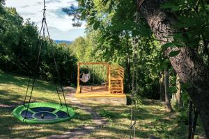 une balançoire dans une cour avec un arbre dans l'établissement Mountain Family Chalet on Prahova Valley, à Comarnic