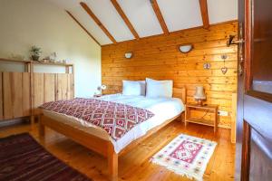 - une chambre avec un lit et un mur en bois dans l'établissement Mountain Family Chalet on Prahova Valley, à Comarnic