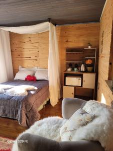 1 dormitorio con 1 cama y 1 sofá en una habitación en Refúgio das Araucárias, en Urubici