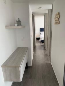 um quarto com paredes brancas e uma mesa de madeira em Hermoso y acogedor apartamento em Dosquebradas