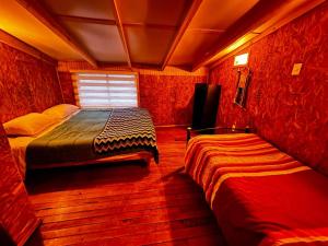 2 łóżka w pokoju z czerwonymi ścianami w obiekcie Ruta 7 Coffee & Lodging w mieście Villa Maniguales