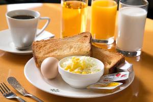 a plate with a sandwich and eggs and a cup of coffee at رويال ماجيك in Cairo