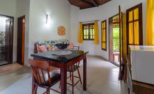 een woonkamer met een tafel, stoelen en een bank bij Sítio de Praia in Arraial d'Ajuda