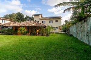 een grote tuin met een huis en een hek bij Sítio de Praia in Arraial d'Ajuda