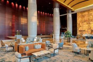 a lobby of a hotel with tables and chairs at Conrad Dubai in Dubai