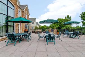 a patio with tables and chairs with umbrellas at Homewood Suites by Hilton Stratford in Stratford