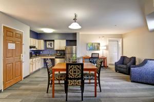 a kitchen and living room with a table and chairs at Homewood Suites by Hilton Stratford in Stratford