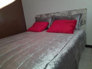 a large bed with two red pillows on it at superbe appartement bien placé in Fez