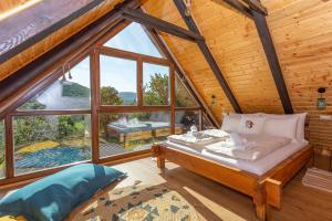 a bed in a room with a large window at Hedgehog's Home in Korenica