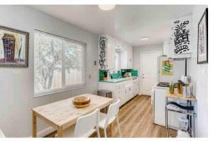 a kitchen with a wooden table and white cabinets at Smart Eclectic ART HOUSE near UC Davis Med Center in Sacramento