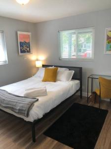 a bedroom with a large white bed with a table at Smart Eclectic ART HOUSE near UC Davis Med Center in Sacramento