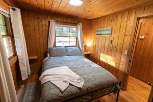 a bedroom with a bed in a wooden cabin at Athens and Albany's Hillside Haven in Albany