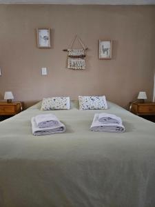 a bedroom with a bed with towels on it at Las Adelas Chaltén in El Chalten