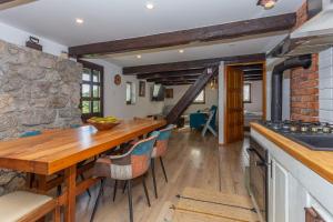 a kitchen with a wooden table and a stone wall at Hedgehog's Home in Korenica